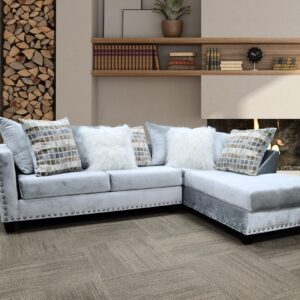 light grey velvet sectional sofa with chaise, nailhead trim, and accent pillows in modern living room