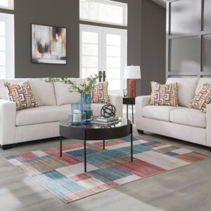 Modern stone sofa and loveseat set with soft fabric upholstery and colorful geometric accent pillows