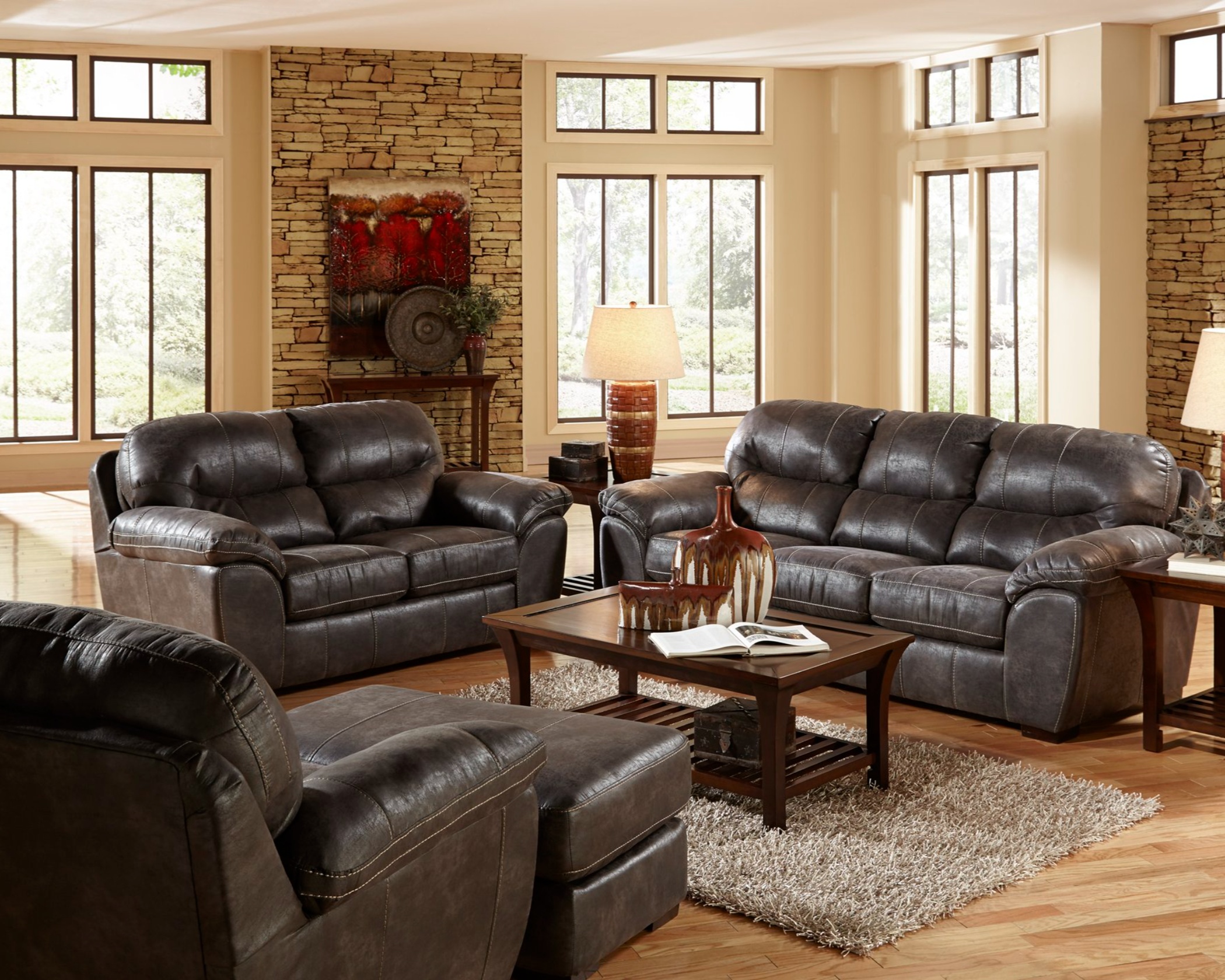 4453 Grant Steel sofa and loveseat set with dark gray leather-look upholstery, plush cushions, and matching ottoman in a modern living room