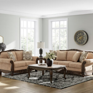 Traditional golden beige sofa and loveseat set with carved wood trim and elegant accent pillows