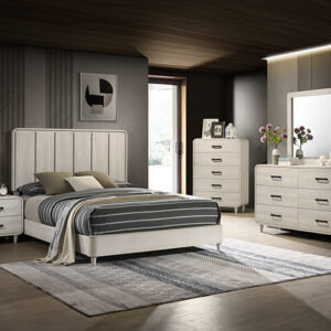 Nyomi 7-piece bedroom set with upholstered panel bed, dresser, mirror, chest, and nightstand in a light neutral finish with modern styling.