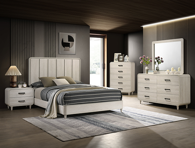 Nyomi 7-piece bedroom set with upholstered panel bed, dresser, mirror, chest, and nightstand in a light neutral finish with modern styling.